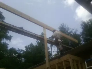 Carpenter setting a ridge beam over a new addition frame — Ice Dam Removal by Roofing Brothers in Canterbury