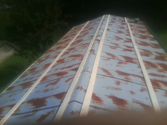 Rusted metal roof panels with new wood purlins before replacement — Storm Damage Roof Repair in Canterbury by Roofing Brothers